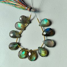 a necklace made out of labradorite beads and tassels on a white surface