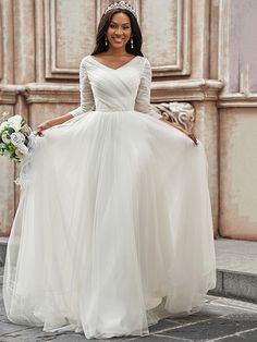 a woman in a white wedding dress is posing for the camera while wearing a tiara