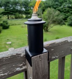 a light that is sitting on top of a wooden post in front of a fence