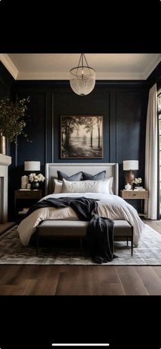 a bedroom with dark walls and wood floors, white bedding, black headboard