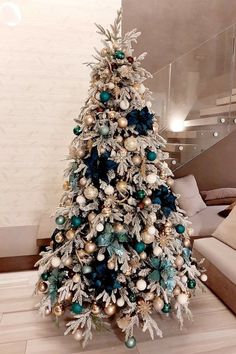 a white christmas tree with blue and gold ornaments