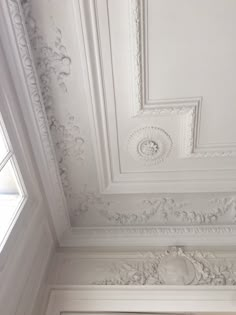 the ceiling is painted white and has ornate designs on it