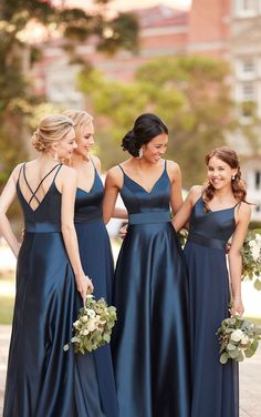 three bridesmaids in blue dresses standing next to each other