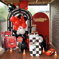 cars themed birthday party with balloons and race car decorations on the front porch for kids to enjoy