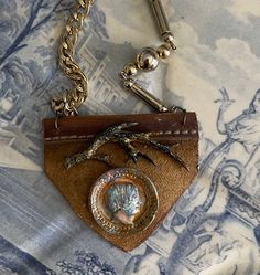 a small purse with a chain hanging from it's side on top of a bed