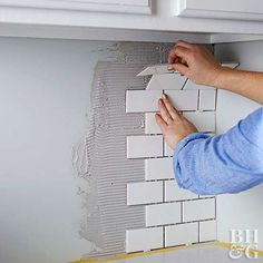 a man is working on a wall in the kitchen