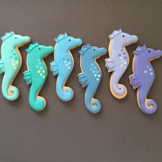 five decorated cookies in the shape of seahorses are lined up on a table