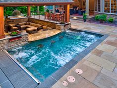 an outdoor living area with a pool and hot tub