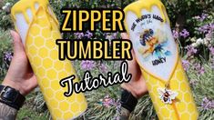 someone holding two bees in their hands with the words zipper tumbler on them