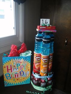 there is a birthday cake and some sodas on the table next to each other