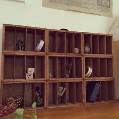 a wooden shelf filled with lots of different items on top of a hard wood floor