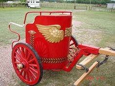 an old fashioned red wagon with wings on it