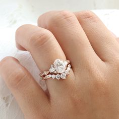 a woman's hand with a diamond ring on top of her finger and an engagement band