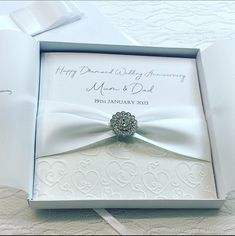 a wedding ring in a white box on a lace tablecloth with the date printed on it