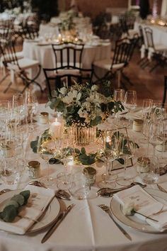 the table is set with many glasses and place settings for guests to sit down at