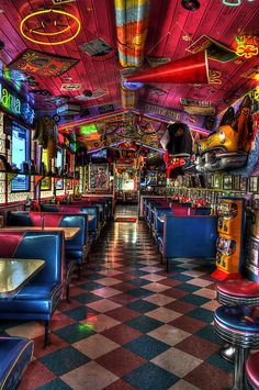 a brightly lit diner with checkered flooring and neon lights on the ceiling is pictured