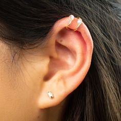 a close up of a person's ear with two piercings on top of it