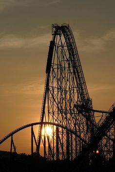 the sun is setting behind a roller coaster at an amusement park in california, usa