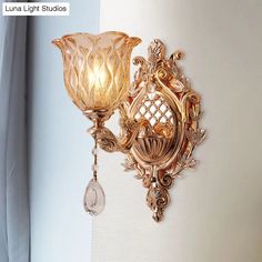 a wall light with a glass shade hanging from it's side