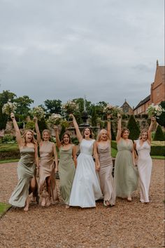 a group of women standing next to each other holding their arms in the air and smiling