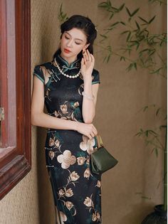 Step into elegance with this luxurious black silk qipao adorned with an exquisite floral design. The dress features a high Mandarin collar and traditional frog buttons, giving it a refined, authentic look. The rich green floral motif, interspersed with delicate cream and gold blossoms, adds a touch of nature-inspired beauty, making it perfect for formal occasions, evening events, or as a statement piece for special gatherings. Material: 90% Mulberry Silk, 10% Spandex Size Guide: Please note Asia Elegant Floral Print Cheongsam With Stand Collar, Elegant Fitted Cheongsam With Floral Print, Green Elegant Cheongsam With Stand Collar, Elegant Green Cheongsam With Stand Collar, Elegant Black Cheongsam For Spring, Elegant Green Dress With Stand Collar, Elegant Fitted Black Cheongsam, Traditional Floral Print Formal Dress, Black Fitted Cheongsam For Formal Occasions