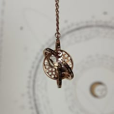 a close up of a necklace on a chain with an animal charm hanging from it's center