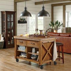 a kitchen island sitting in the middle of a living room next to a leather couch