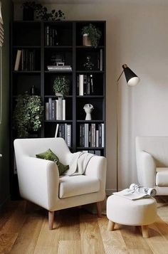 a living room filled with white furniture and bookshelves