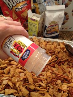 a person is dipping chips into a container