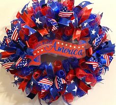 a patriotic wreath with red, white and blue ribbons on it that says america in the center