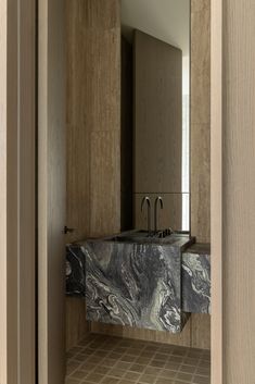 a bathroom sink sitting under a mirror next to a wooden cabinet with two faucets