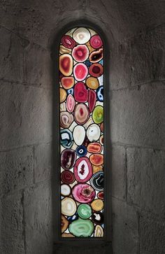 a stained glass window in an old stone building with lots of different colors and shapes