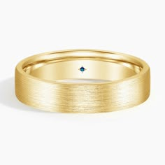 a yellow gold wedding band with a blue diamond in the center