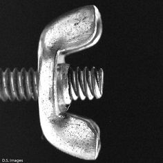 a close up of a metal object on a black background with the letter e in it