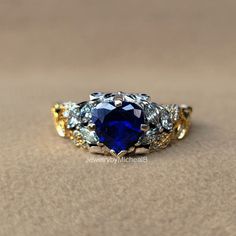 Welcome to our shop "JewelrybyMichealB"  ● Victorian Style Wedding Ring Heart Cut Blue Sapphire Bridal Ring 14k Two tone Gold Ring Unique Leaf Style Engagement Ring Anniversary Gifts  Item Description and specifications: ● Design Code : PEBRM-18 ● Main Stone Details  -  Type      :- Sapphire (Lab Created) -  Shape   :- Heart Cut  -  Size       :- 7 mm. (± 0.20) - Weight   :- 1.13 Ct (Diamond Equivalent) -  Color     :- Blue -  Clarity   :- VVS-VS ● Side Stone Details  -  Type      :- CZ - High Quality -  Shape   :- Round & Marquise Cut  - Weight   :- 0.45 Ct (Diamond Equivalent) -  Color     :- Colorless -  Clarity   :- VVS-VS ● Metal Details - Metal type: Silver, Gold, Platinum - Metal Purity: 925, 10k, 14k, 18k - Metal Tone: White, Rose, Yellow - Metal Stamp: Yes ● 𝗖𝘂𝘀𝘁𝗼𝗺𝗶𝘇𝗲 𝗢? Wedding Ring Heart, Victorian Style Wedding, Blue Sapphire Wedding Ring, Gold Ring Unique, Heart Wedding Rings, Ring Heart, Rose Yellow, Platinum Metal, Ring Unique