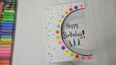 a birthday card with candles on it next to colored crayons and paper straws