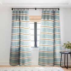 the curtains in this room are striped and have tassels on them