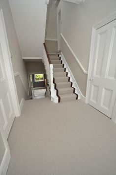 an empty room with stairs leading up to the second floor and another door on the other side