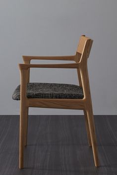 a wooden chair sitting on top of a hard wood floor next to a gray wall