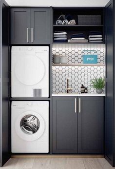 a washer and dryer in a small laundry room with gray cabinetry, white tile backsplash and shelves