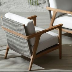 two chairs sitting on top of a wooden floor next to each other with white cushions