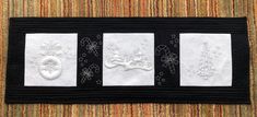 three black and white hand towels with embroidered designs on them