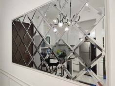 a mirror reflecting the kitchen and dining room in it's own reflection on the wall