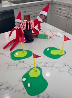 two elfs are playing golf on the kitchen counter