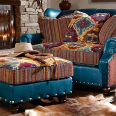 a living room with a blue couch and ottoman next to a fire place in the fireplace