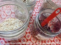 three glass jars filled with oatmeal sitting on top of a red and white table cloth