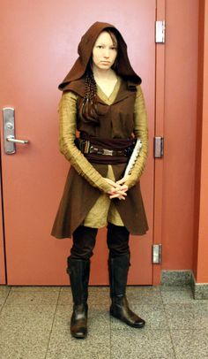 a woman dressed as star wars character, standing in front of a door with her hands on her hips