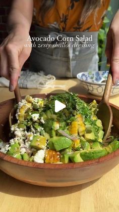 a person cutting into a salad in a bowl