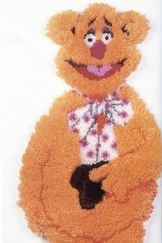 an orange teddy bear wearing a flowered dress