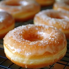 several glazed donuts are cooling on a rack